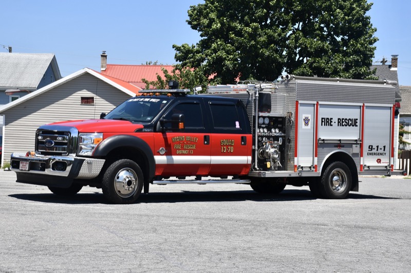 Squad 13-70, a red Ford F-550 crew cab with a Rosenbauer mini-pumper body, parked in front of houses. Photo: Mike and Andrew Sanders.